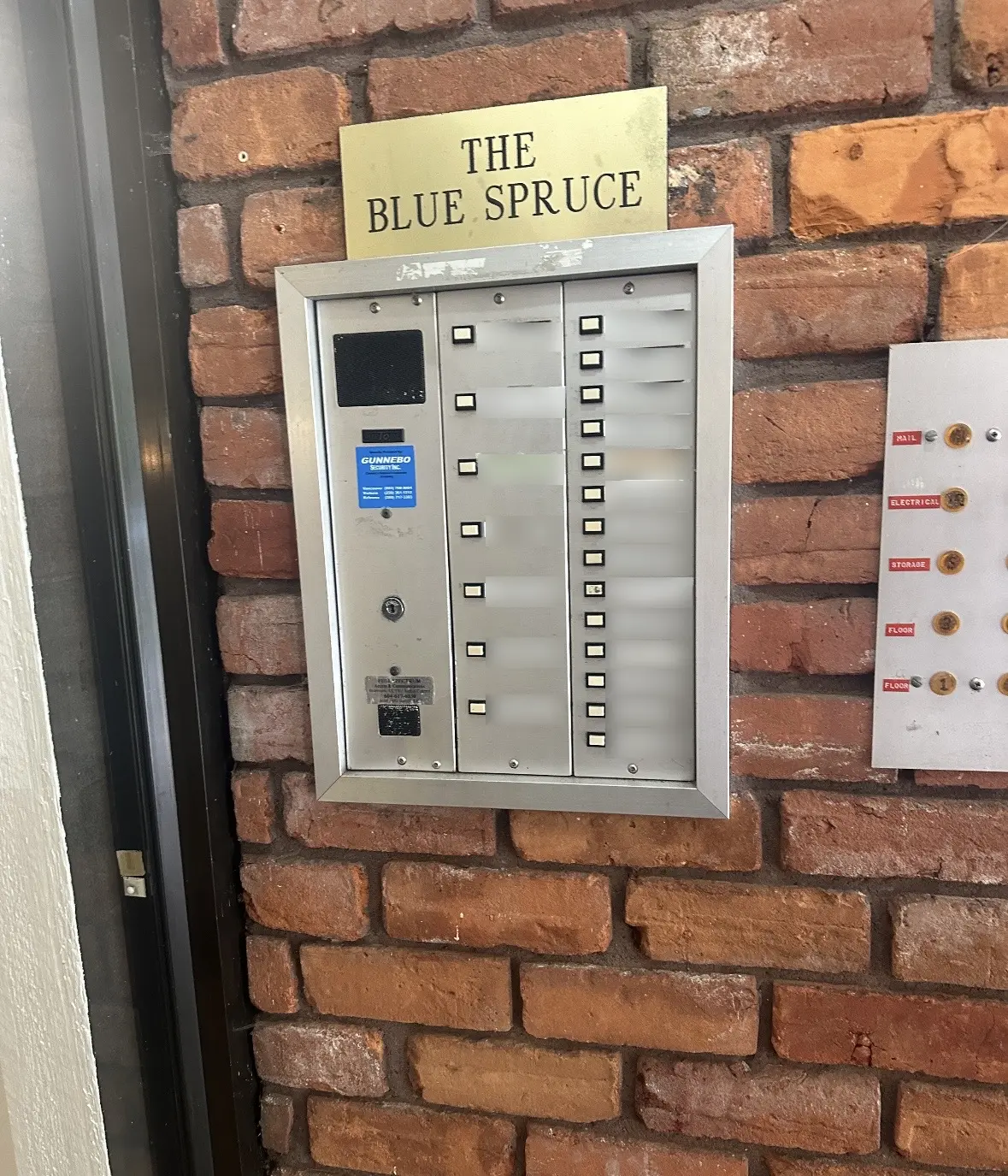 Privacy-edited photo of the old Blue Spruce audio intercom before upgrade with all resident labels blurred