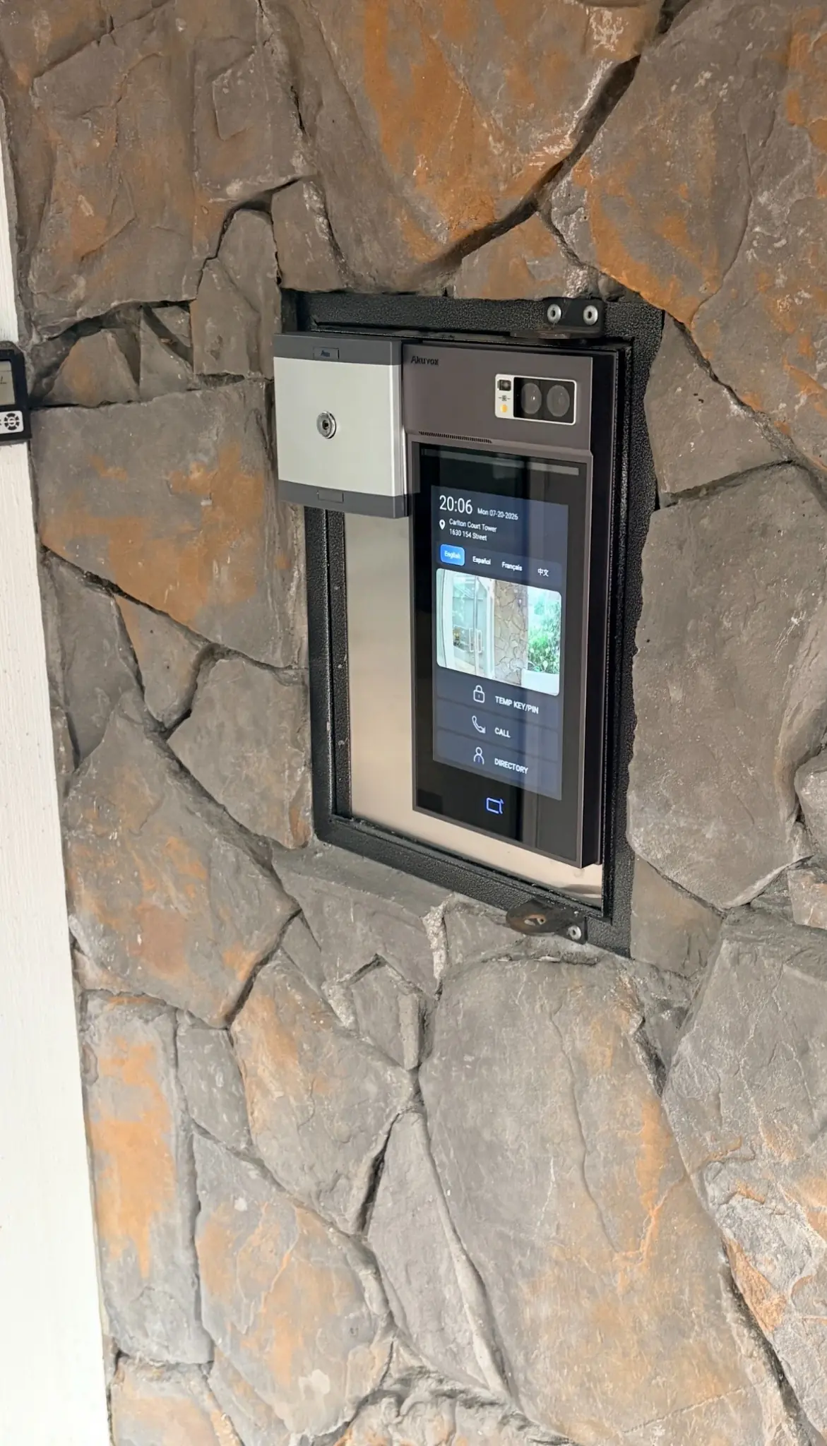 Angled view of the Akuvox video intercom installed in the stone gate entrance at Carlton Court in Surrey