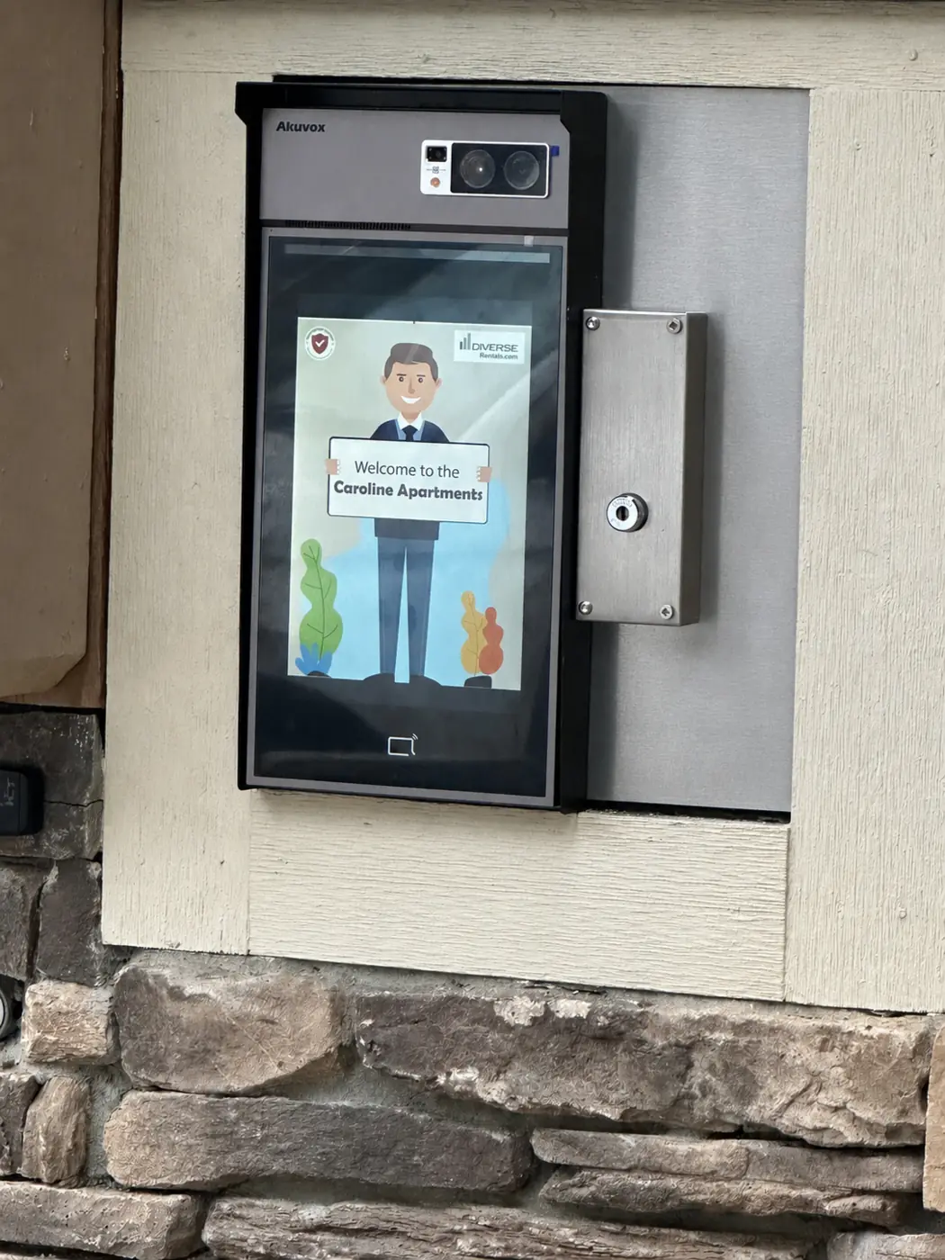 Akuvox video intercom at Caroline Apartments displaying a custom Diverse Rentals branded welcome screen