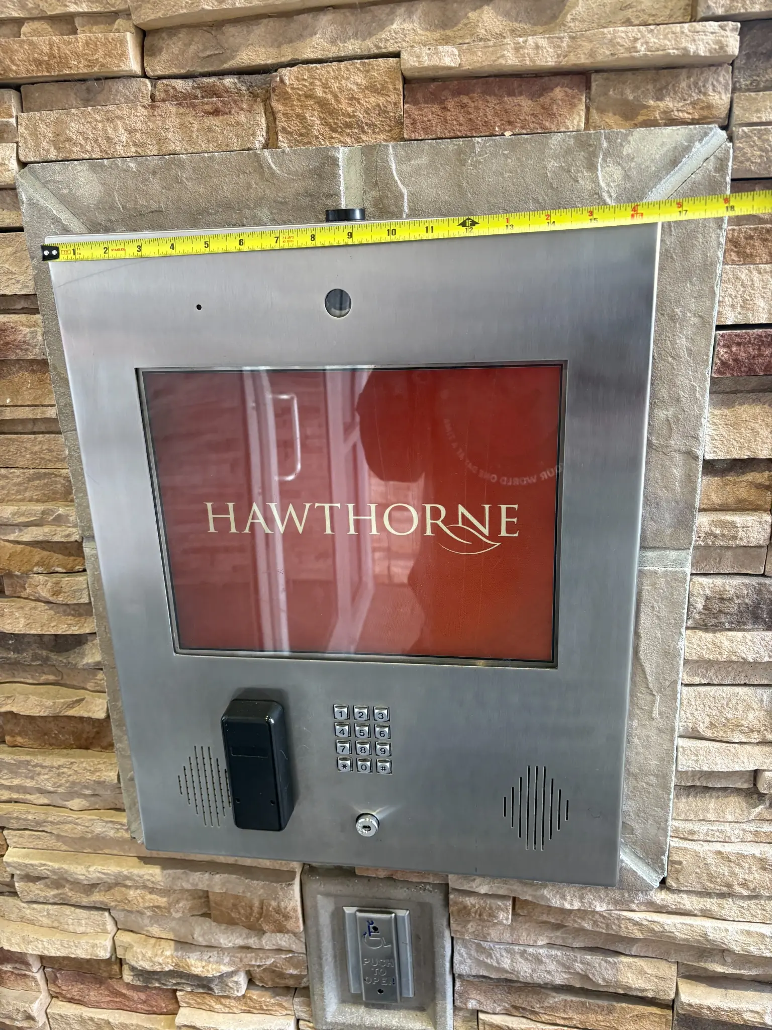 Before photo of the Hawthorne legacy building intercom and keypad set into the stone entrance wall at 8915 202 Street in Langley