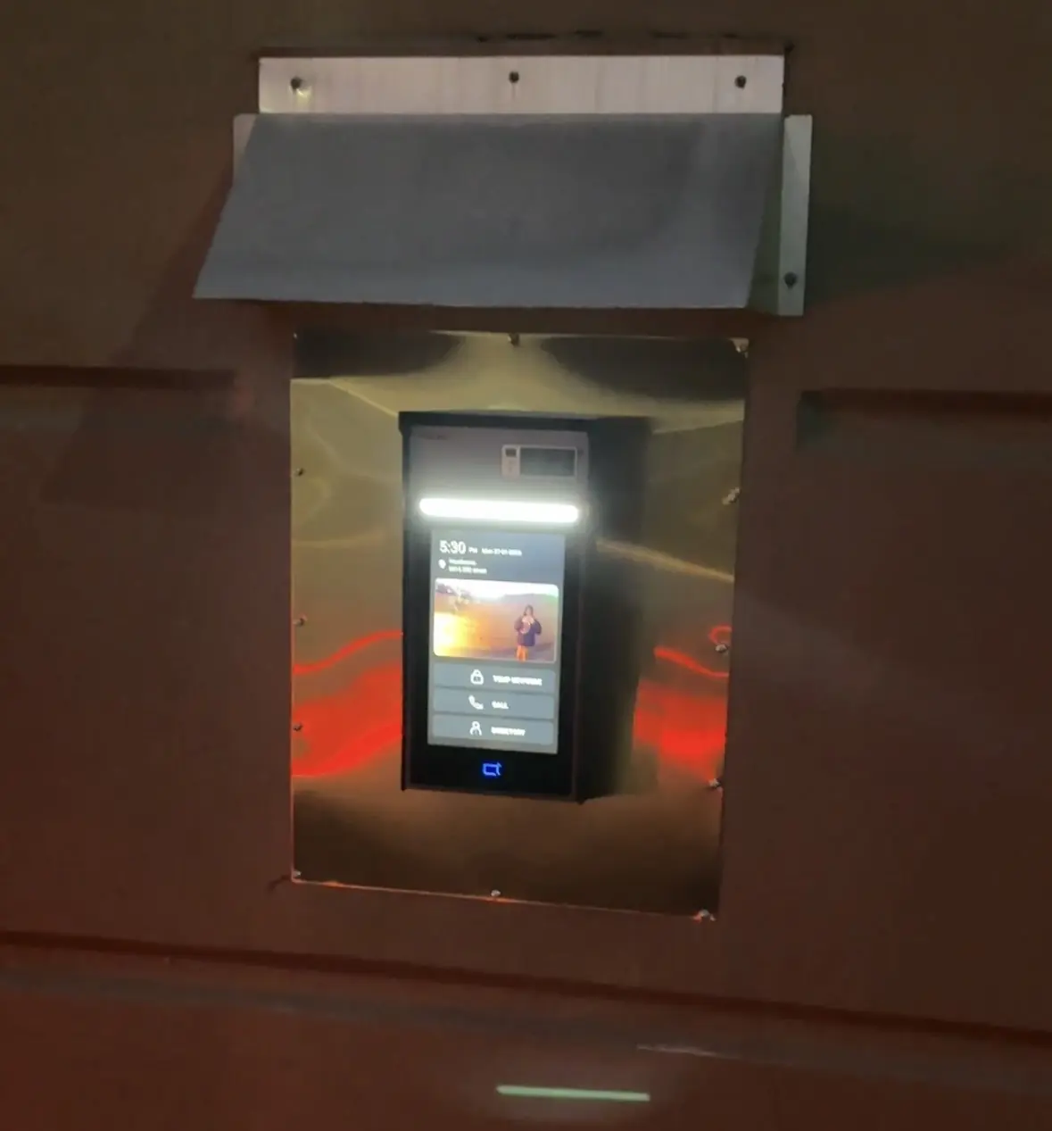 Exterior Akuvox video intercom with a metal weather hood installed at Hawthorne in Langley