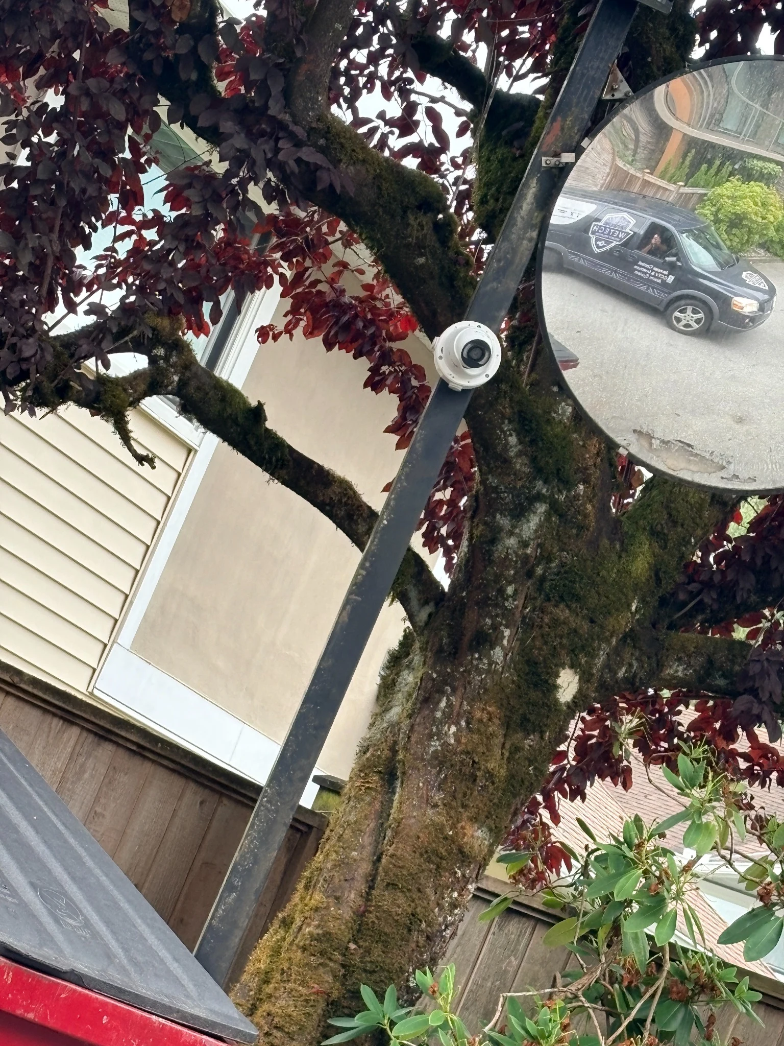 Second Hikvision security camera mounted beside a convex mirror at Highpoint Gardens in Guildford, Surrey