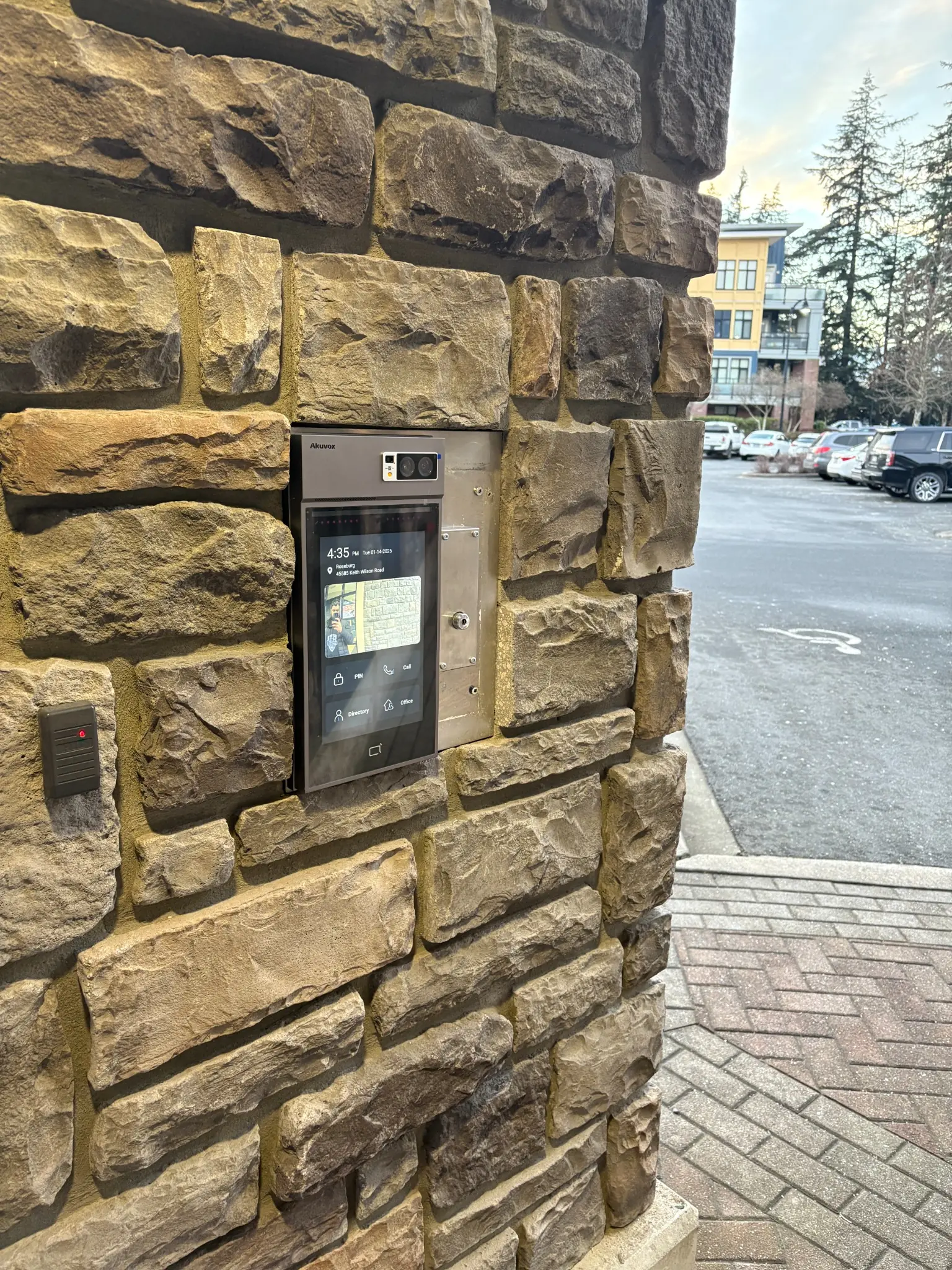 Akuvox video intercom and credential reader integrated into the stone entrance at Roseburg Apartments in Chilliwack