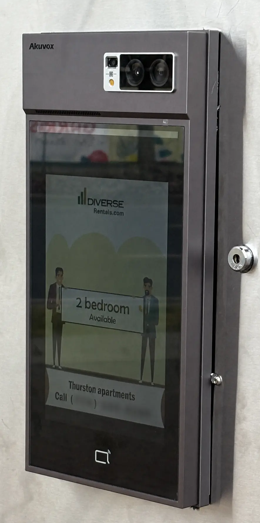 Akuvox video intercom at Thurston Apartments displaying a two-bedroom rental advertisement with the phone number blurred
